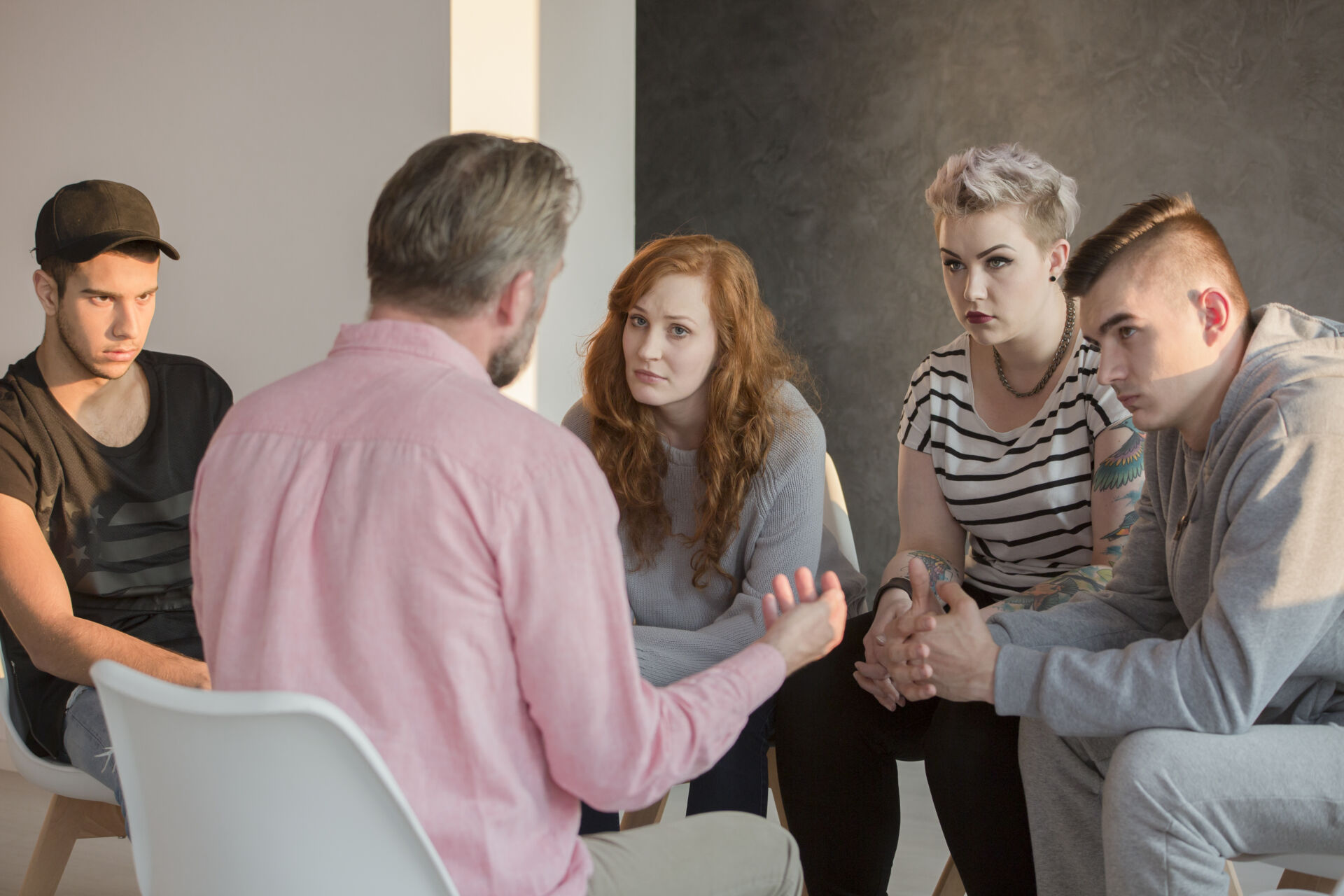 Safeguarding Children in Specialist Residential Care Addiction counselor talking to group of his teenage patients